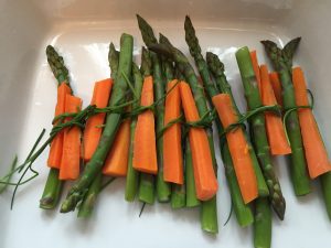 Zusammengeknotete Spargel-Karotten-Päckchen